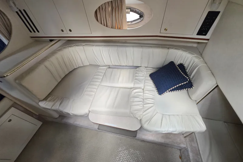 Slide: The Image of Interior of 2000 Sea Ray 290 Amberjack with white leather seating and blue cushion. - 9
