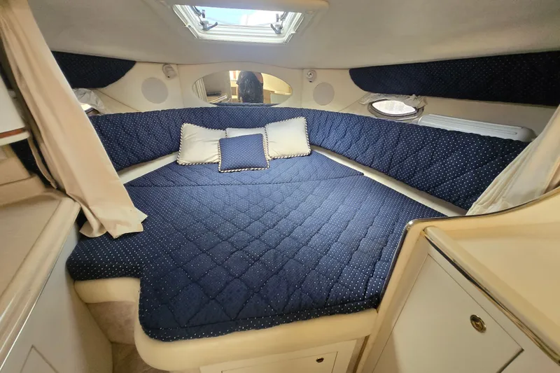 Slide: The Image of Cozy cabin interior of 2000 Sea Ray 290 Amberjack with blue quilted bedding. - 10
