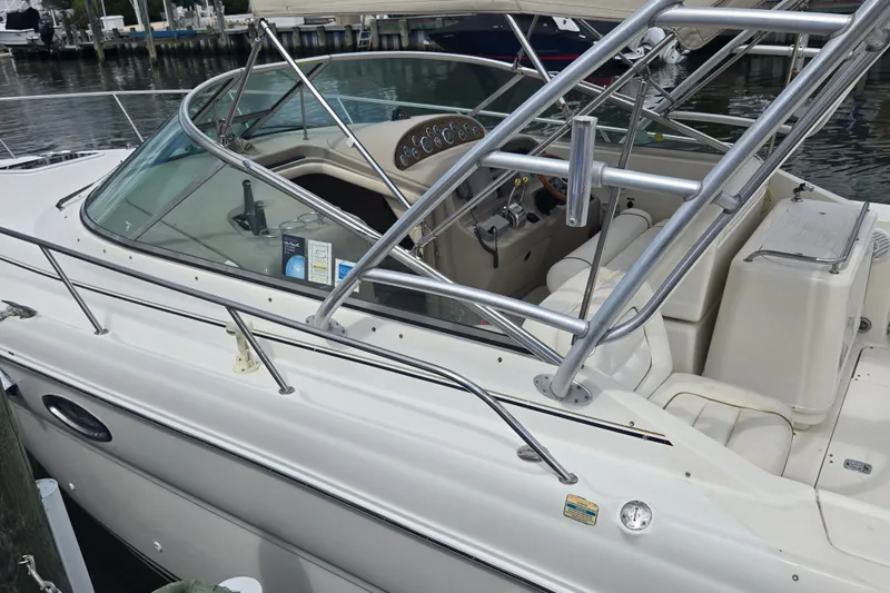 Slide: The Image of 2000 Sea Ray 290 Amberjack boat docked, showcasing cockpit and seating area. - 18