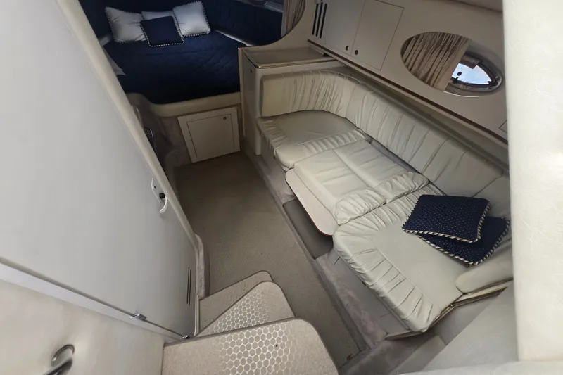 Slide: The Image of Interior of 2000 Sea Ray 290 Amberjack with cozy seating and bedding. - 2