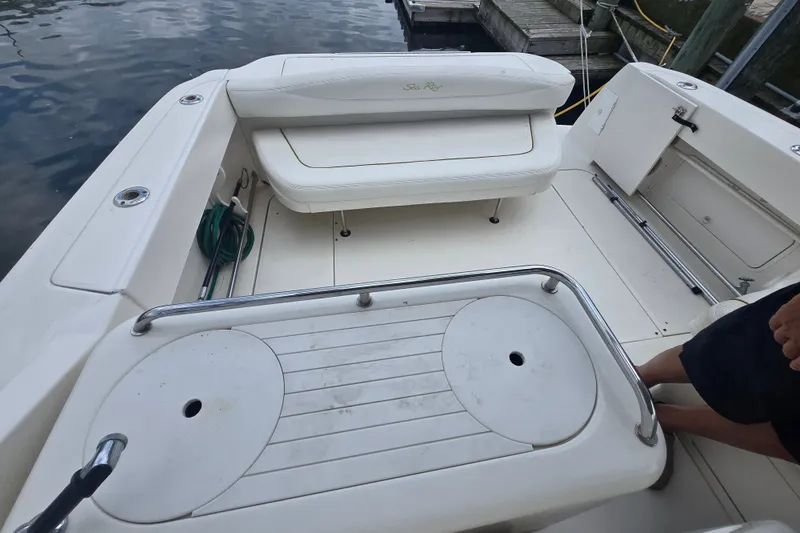 Slide: The Image of 2000 Sea Ray 290 Amberjack boat deck with seating and railing, docked by the water. - 5