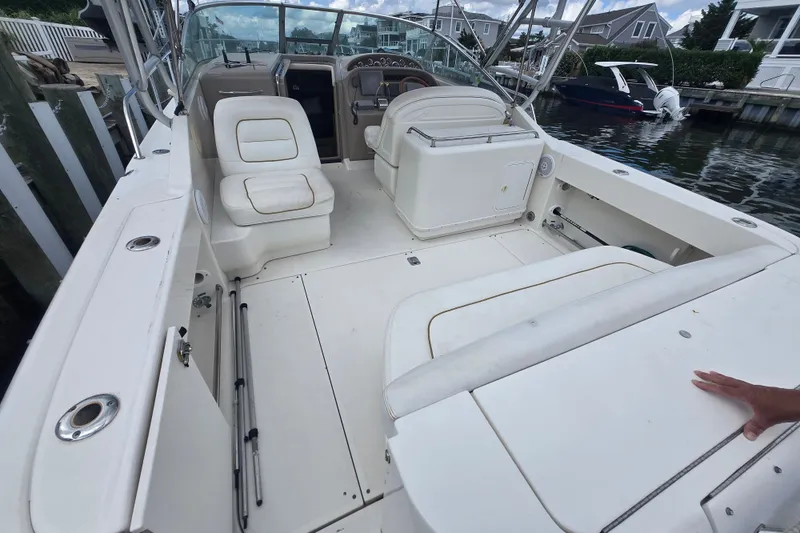 Slide: The Image of 2000 Sea Ray 290 Amberjack boat interior with seating and helm, docked by the water. - 3