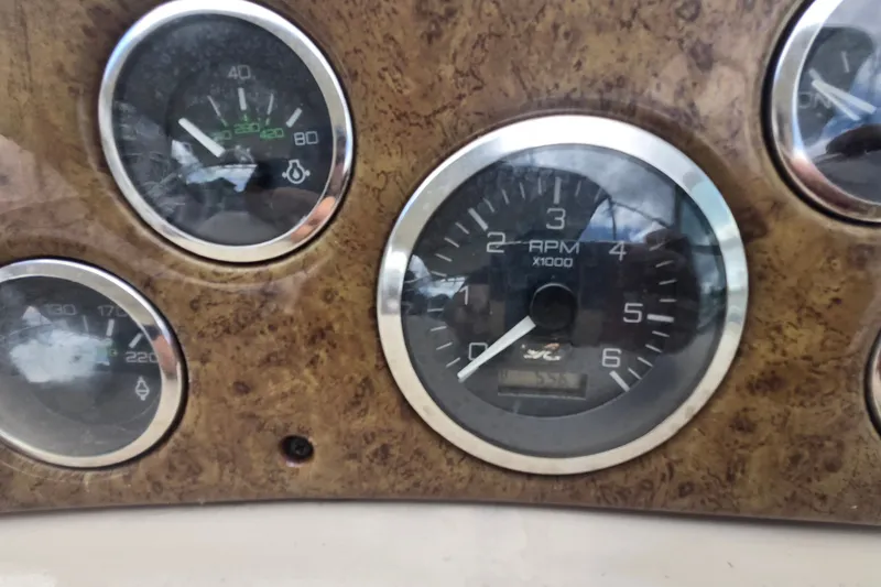 Slide: The Image of Dashboard gauges of a 2000 Sea Ray 290 Amberjack boat, featuring RPM and pressure indicators. - 24