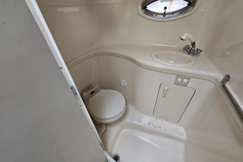 Slide: The Image of 2000 Sea Ray 290 Amberjack boat bathroom with toilet, sink, and porthole window. - 17