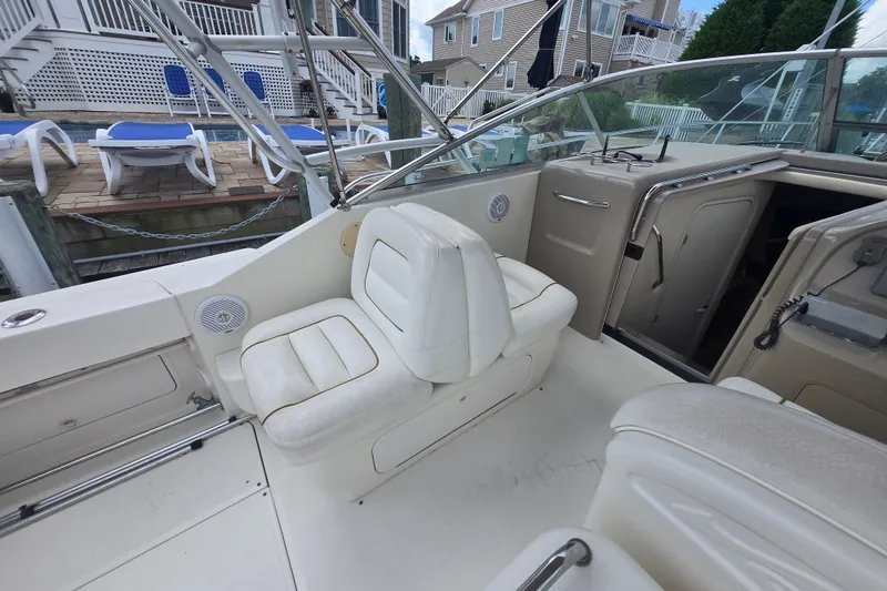 Slide: The Image of Interior of 2000 Sea Ray 290 Amberjack boat with white seating and deck view. - 12