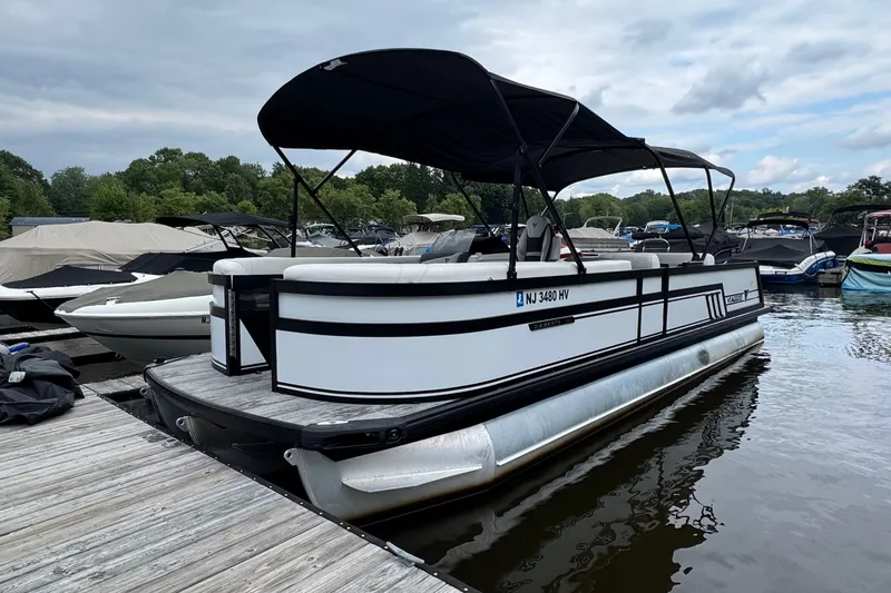 Slide: The Image of 2026 Viaggio Diamante S 26 pontoon boat docked on a calm lake. - 1