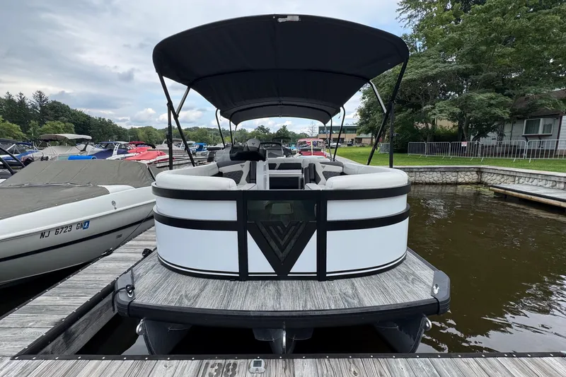 Slide: The Image of 2026 Viaggio Diamante S 26 pontoon boat docked at a marina, featuring sleek design and canopy. - 2
