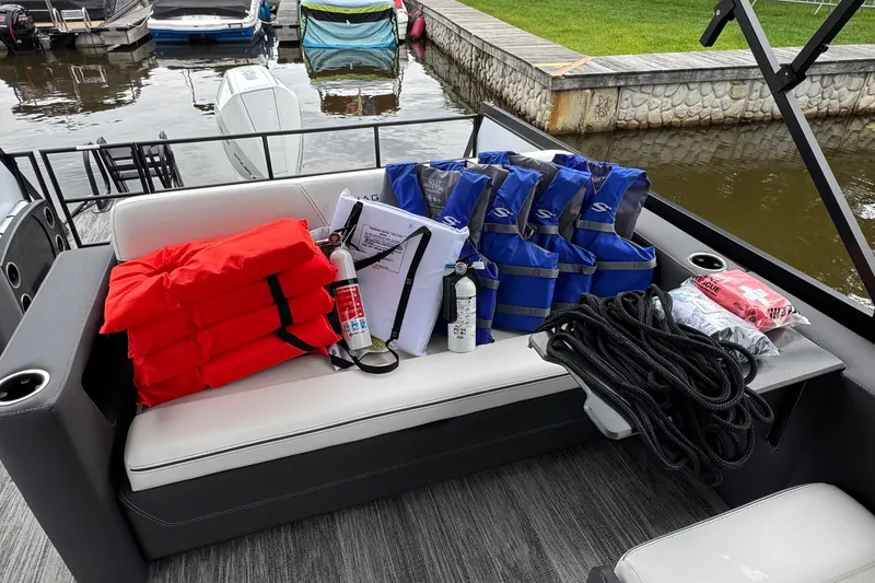 Slide: The Image of Safety equipment on Viaggio Diamante S 26 boat, including life jackets and fire extinguishers, docked by water. - 27