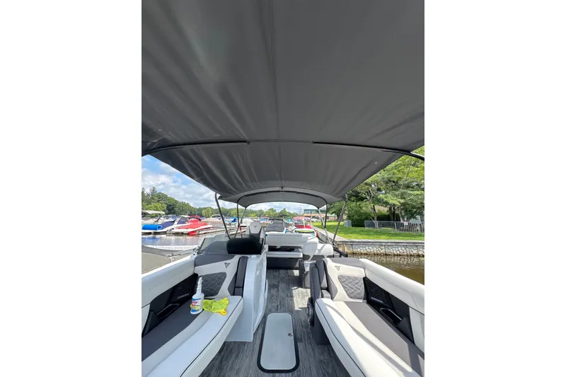 Slide: The Image of 2026 Viaggio Diamante S 26 boat interior with canopy, docked near colorful boats. - 3
