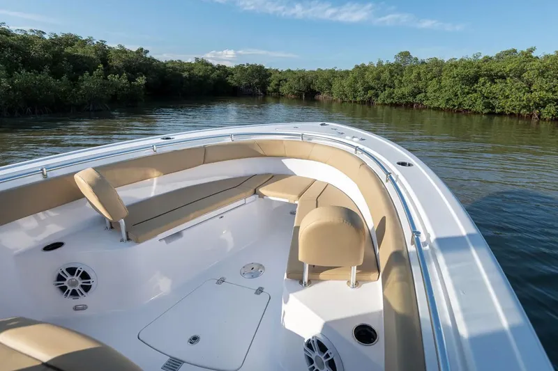 Slide: The Image of Manufacturer Provided Image: 2025 Sportsman Open 252 Center Console boat on calm water, surrounded by lush greenery. - 1