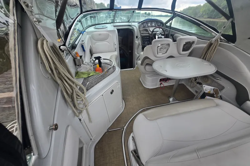 Slide: The Image of Interior of a 2014 Crownline 264 CR boat, featuring seating and a compact table. - 9