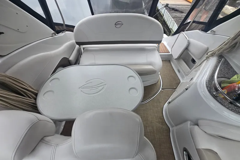 Slide: The Image of Interior of a 2014 Crownline 264 CR boat with white seating and table. - 15