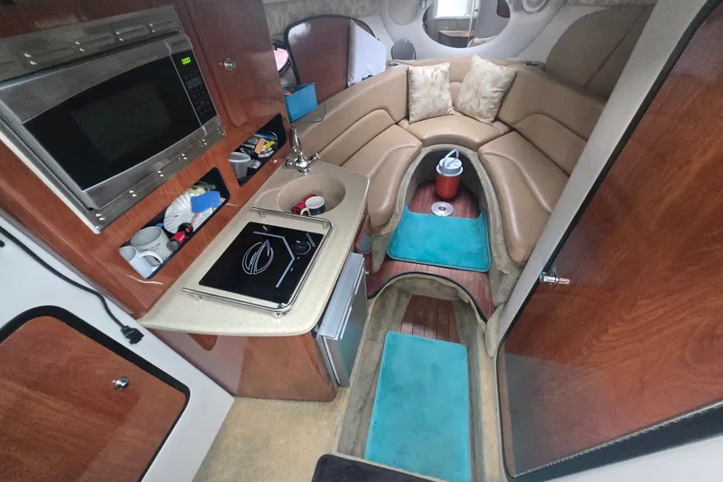 Slide: The Image of Interior of 2014 Crownline 264 CR boat with kitchenette and seating area. - 2