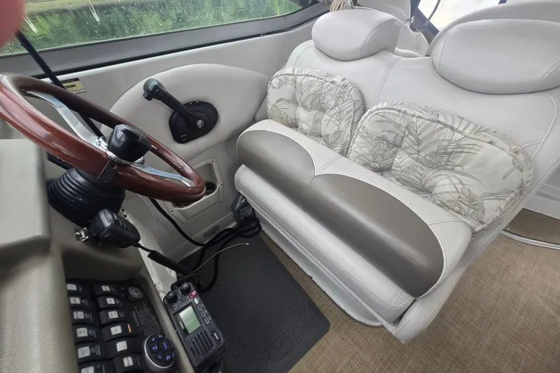 Slide: The Image of Interior of 2014 Crownline 264 CR boat with steering wheel and cushioned seating. - 14