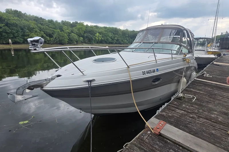 Slide: The Image of 2014 Crownline 264 CR boat docked on a calm river with lush greenery. - 8
