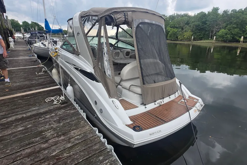 Slide: The Image of 2014 Crownline 264 CR boat docked, featuring a sleek design and covered cockpit. - 3