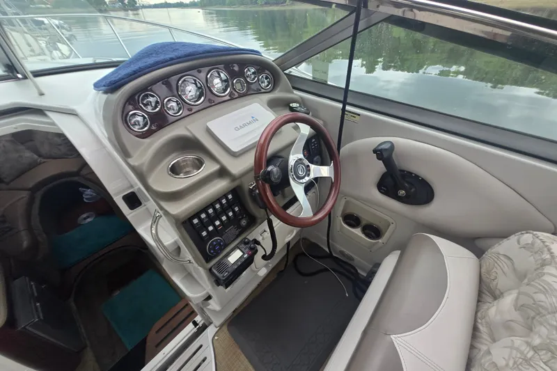 Slide: The Image of 2014 Crownline 264 CR boat cockpit with steering wheel and control panel. - 13