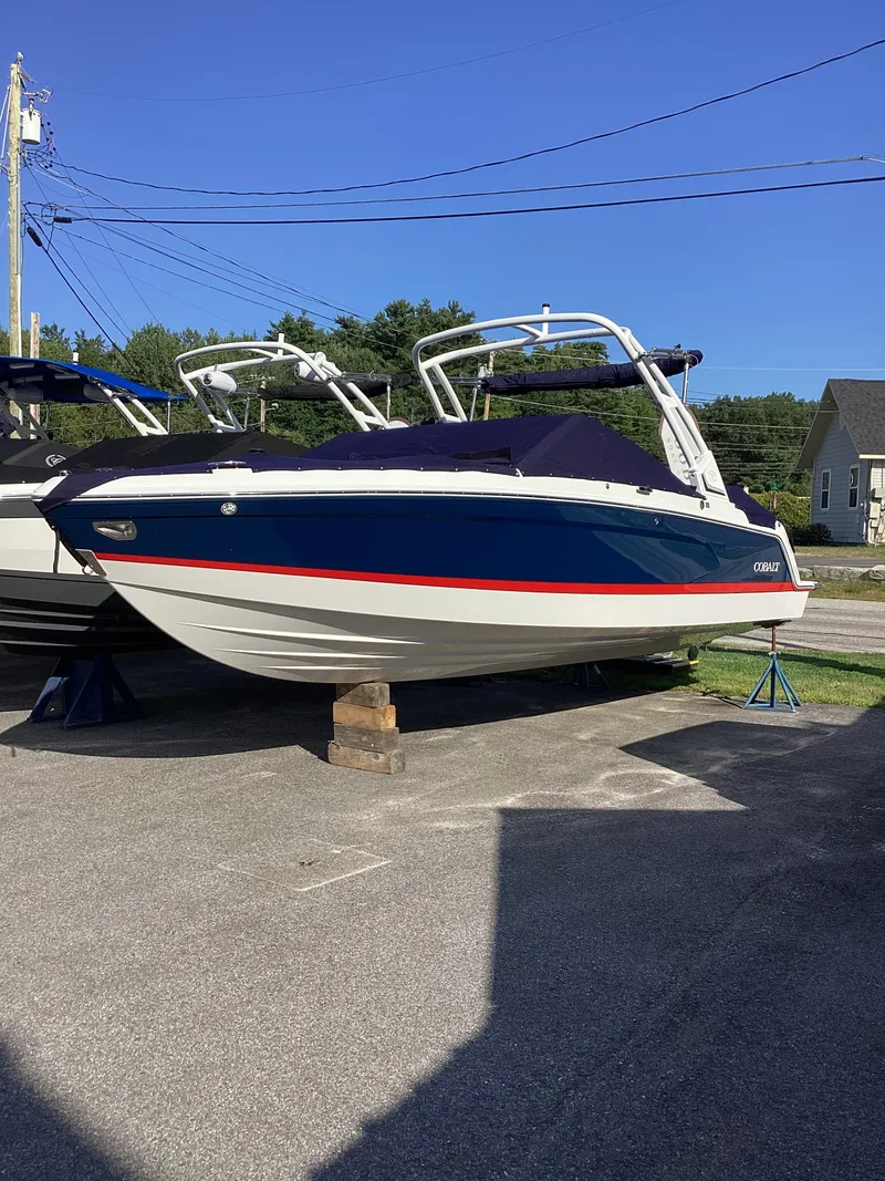 Slide: The Image of A 2027 Cobalt R26 boat is parked on a lot, supported by wooden blocks. - 7
