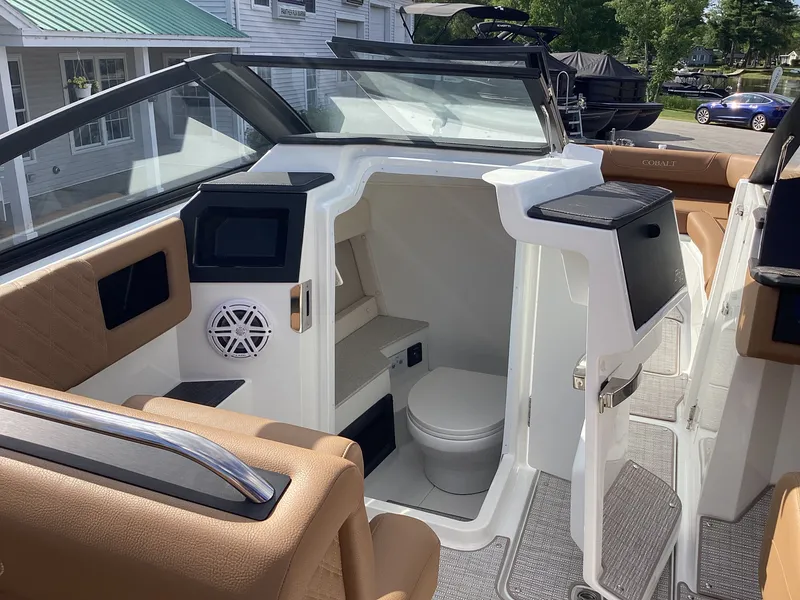 Slide: The Image of The image shows the cockpit of a 2027 Cobalt R26 boat with beige seating and a small bathroom. - 14