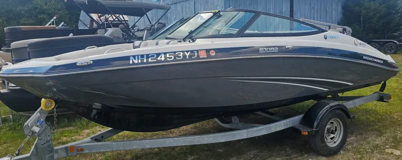 The Image of A 2014 Yamaha SX 192 boat on a trailer, featuring a blue and white color scheme. - 1