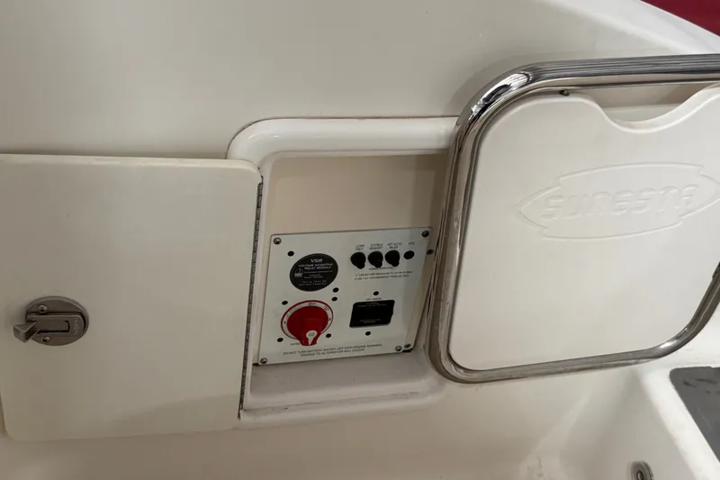 Slide: The Image of Control panel on a 2008 Chaparral Sunesta 284 boat, featuring switches and a storage compartment. - 41