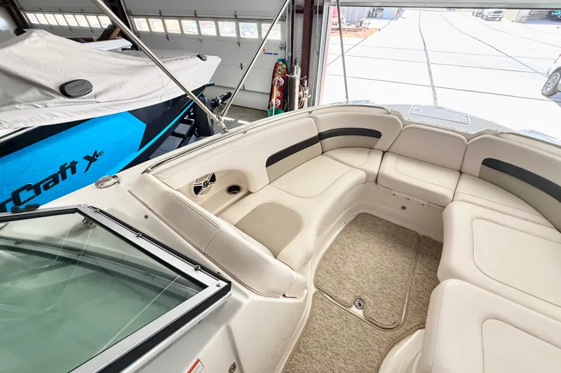 Slide: The Image of 2008 Chaparral Sunesta 284 boat interior with beige seating in a garage. - 31