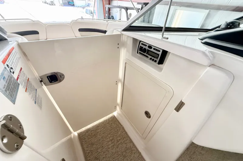 Slide: The Image of 2008 Chaparral Sunesta 284 boat interior with storage compartment and control panel. - 34