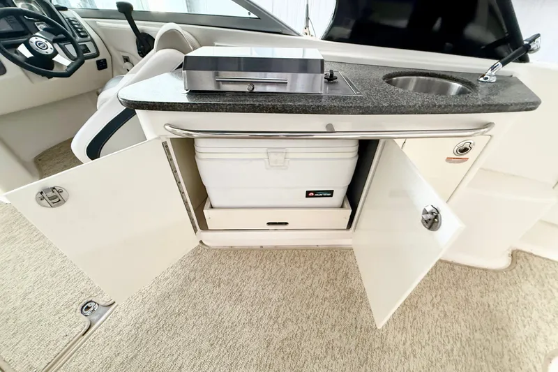 Slide: The Image of 2008 Chaparral Sunesta 284 boat interior with sink, storage, and steering wheel. - 28