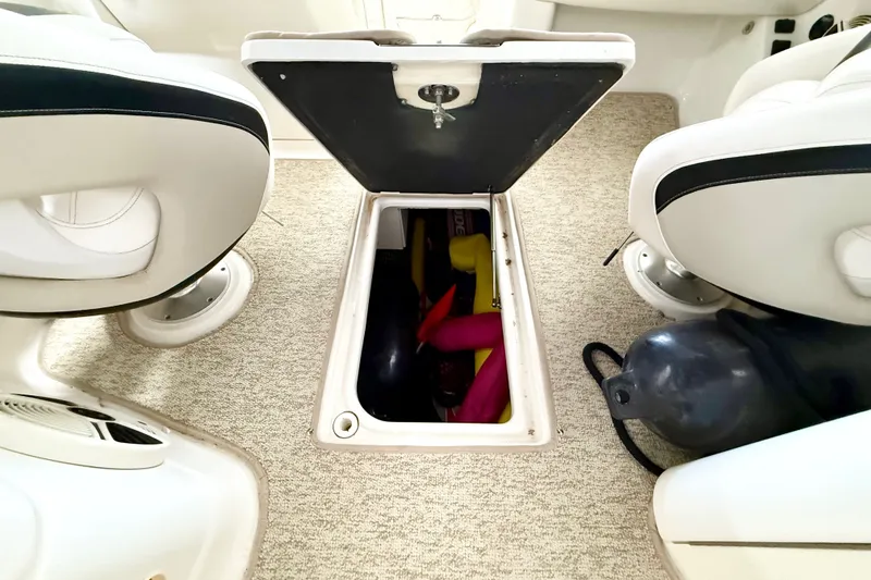 Slide: The Image of 2008 Chaparral Sunesta 284 boat interior storage compartment with open hatch and visible equipment. - 29
