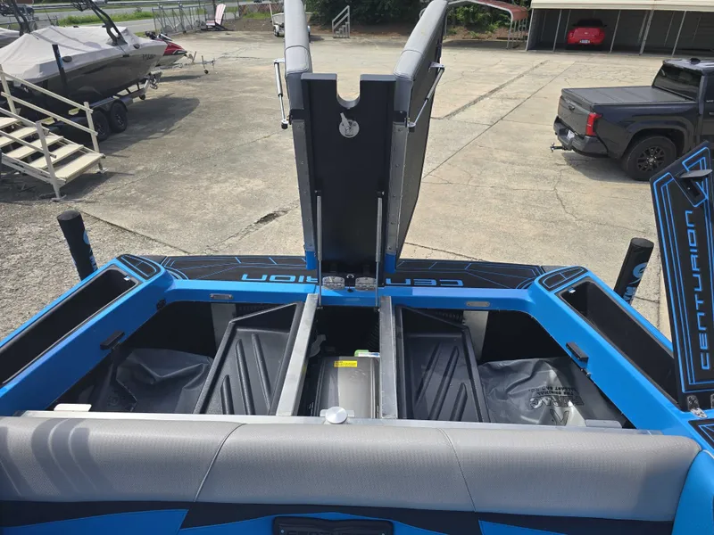 Slide: The Image of The image shows the rear of a blue 2022 Centurion Fi23 boat with open storage compartments. - 15