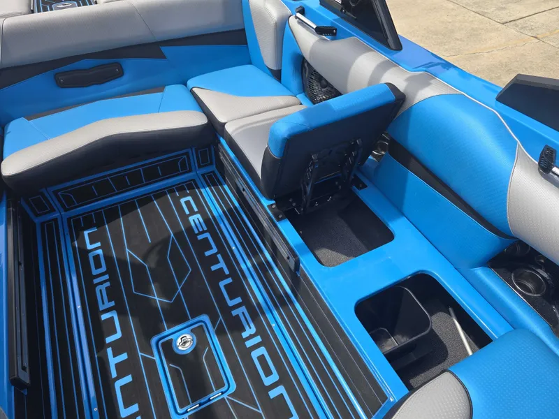 Slide: The Image of The image shows the interior of a 2022 Centurion Fi23 boat with blue and gray seating. - 13