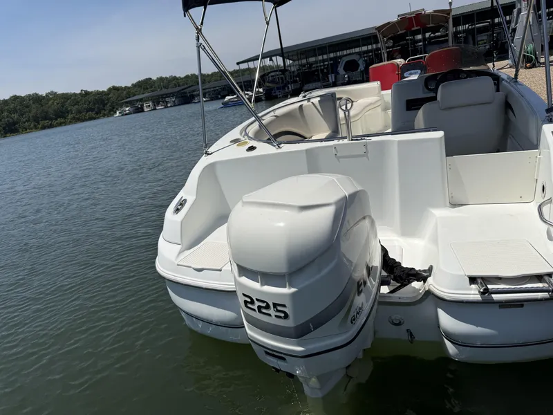 Slide: The Image of A white boat with a 225 HP outboard motor is on the water. Boats and a dock are in the background. - 15