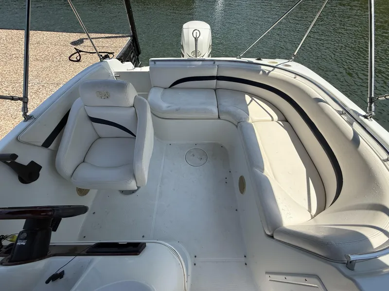 Slide: The Image of The image shows the cockpit of a 2001 Triton Elante 210 boat with white seating. - 19