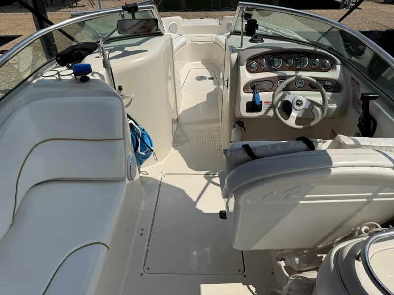 Slide: The Image of The image shows the cockpit of a 2000 Sea Ray 240 Sundeck boat with white seating and a helm. - 15