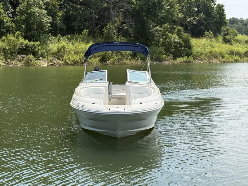 Slide: The Image of A 2000 Sea Ray 240 Sundeck on a calm lake, surrounded by trees. - 11