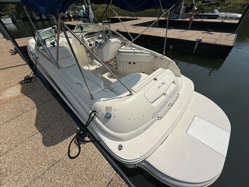 Slide: The Image of A 2000 Sea Ray 240 Sundeck docked. It features a spacious deck and seating area. - 20