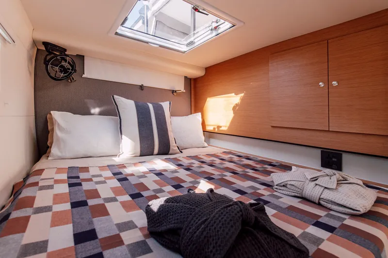 Slide: The Image of Cozy cabin interior of 2024 Vision 444ES yacht with patterned bedding and natural light. - 20