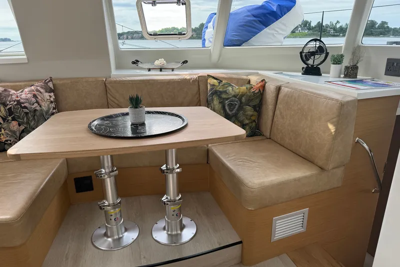 Slide: The Image of Modern Vision 444ES yacht interior with cozy seating, wooden table, and decorative pillows, 2024 model. - 17