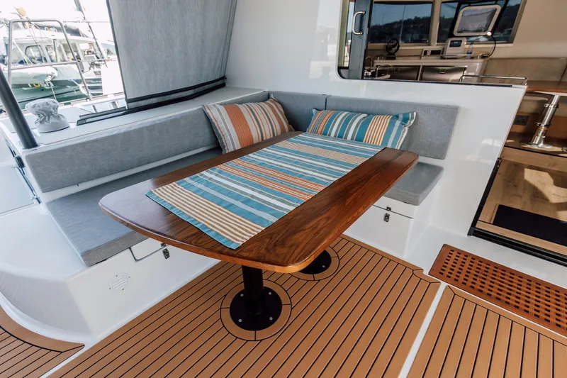 Slide: The Image of Luxurious seating area on 2024 Vision 444ES yacht with striped cushions and wooden table. - 15
