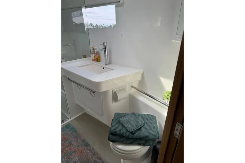 Slide: The Image of Modern bathroom in Vision 444ES 2024 model, featuring sleek sink and toilet with folded towels. - 31
