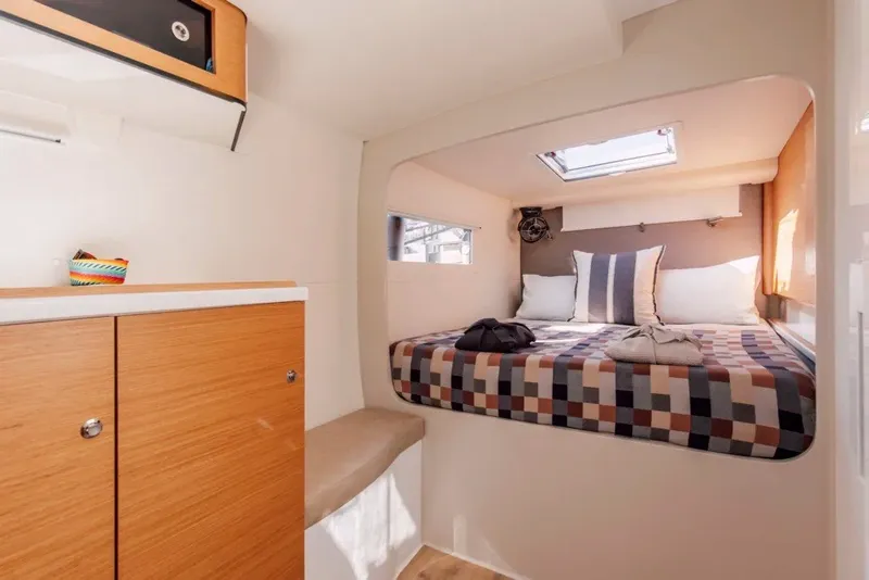 Slide: The Image of Cozy cabin interior of 2024 Vision 444ES with bed, pillows, and wooden cabinetry. - 19