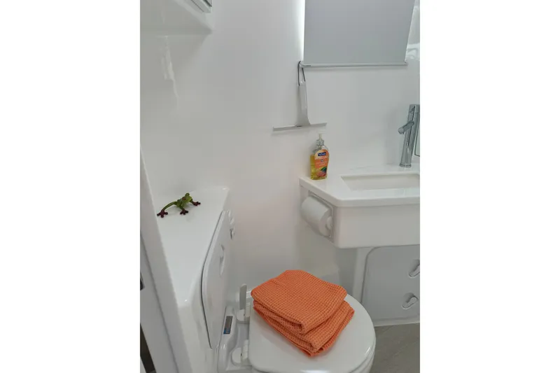 Slide: The Image of Compact bathroom with orange towels, white fixtures, and hand soap, in Vision 444ES 2024 model. - 30