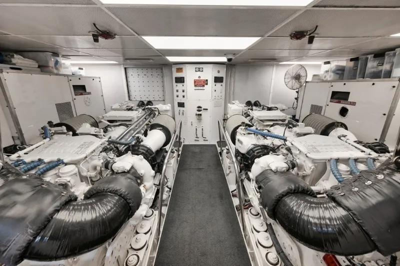 Slide: The Image of Engine room of 2003 Westport 112 Raised Pilothouse yacht, featuring dual engines and control panels. - 42