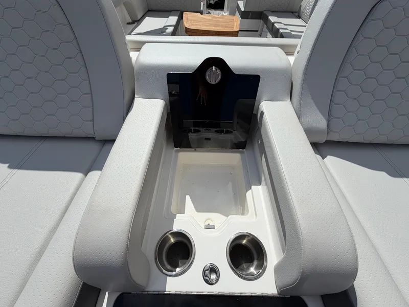 Slide: The Image of The image shows the interior of a 2025 Sea Ray SDX 290 boat with gray upholstery and cup holders. - 8