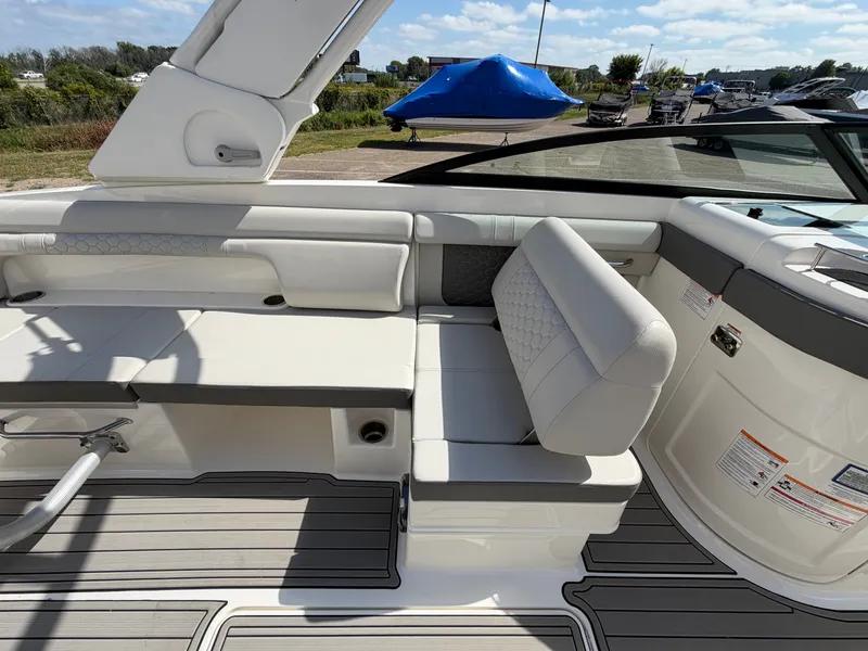 Slide: The Image of The image shows the cockpit of a 2025 Sea Ray SDX 290 with white upholstery and gray flooring. - 33