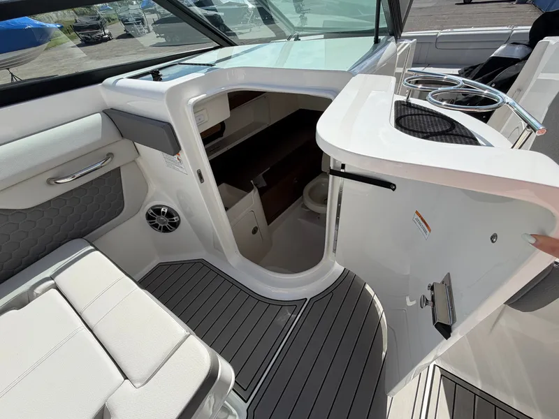 Slide: The Image of The image shows the interior of a 2025 Sea Ray SDX 290 with sleek seating and a small washroom. - 34
