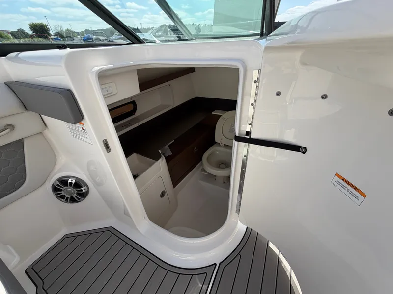 Slide: The Image of The image shows the interior of a 2025 Sea Ray SDX 290 with a small toilet area. - 35