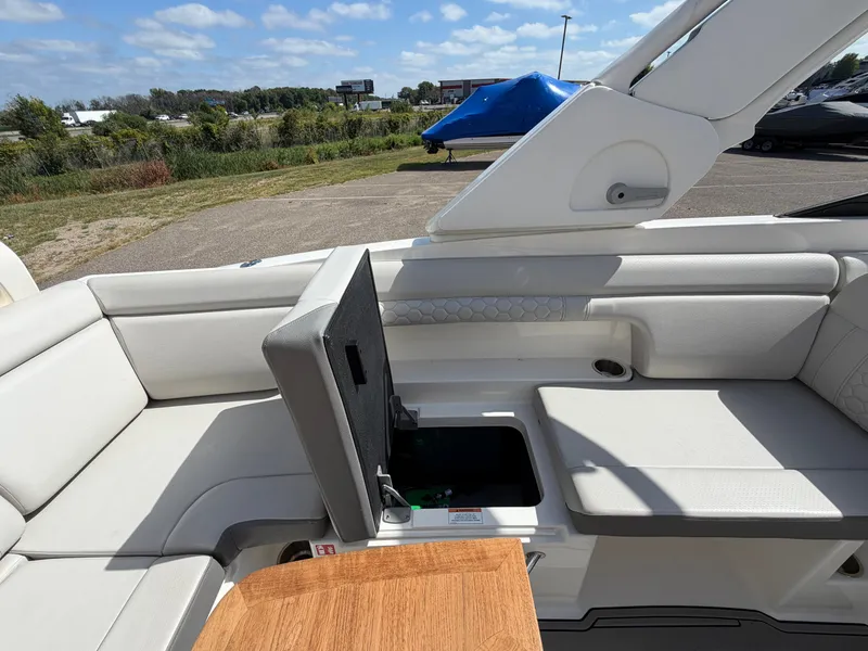 Slide: The Image of The image shows the cockpit of a 2025 Sea Ray SDX 290 with white upholstery and storage space. - 27