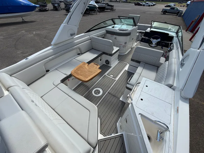 Slide: The Image of The image shows the spacious cockpit of a 2025 Sea Ray SDX 290 with sleek seating and a wooden table. - 13