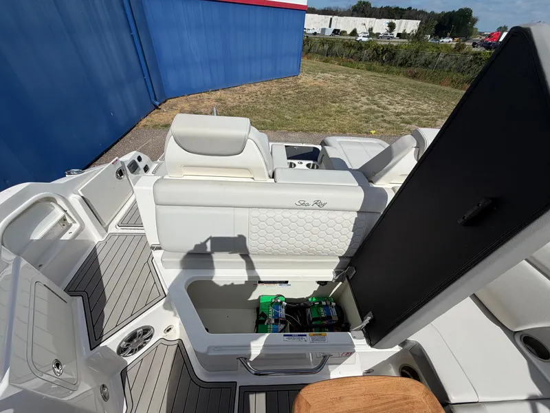 Slide: The Image of The image shows the cockpit of a 2025 Sea Ray SDX 290 with white upholstery and storage space. - 19